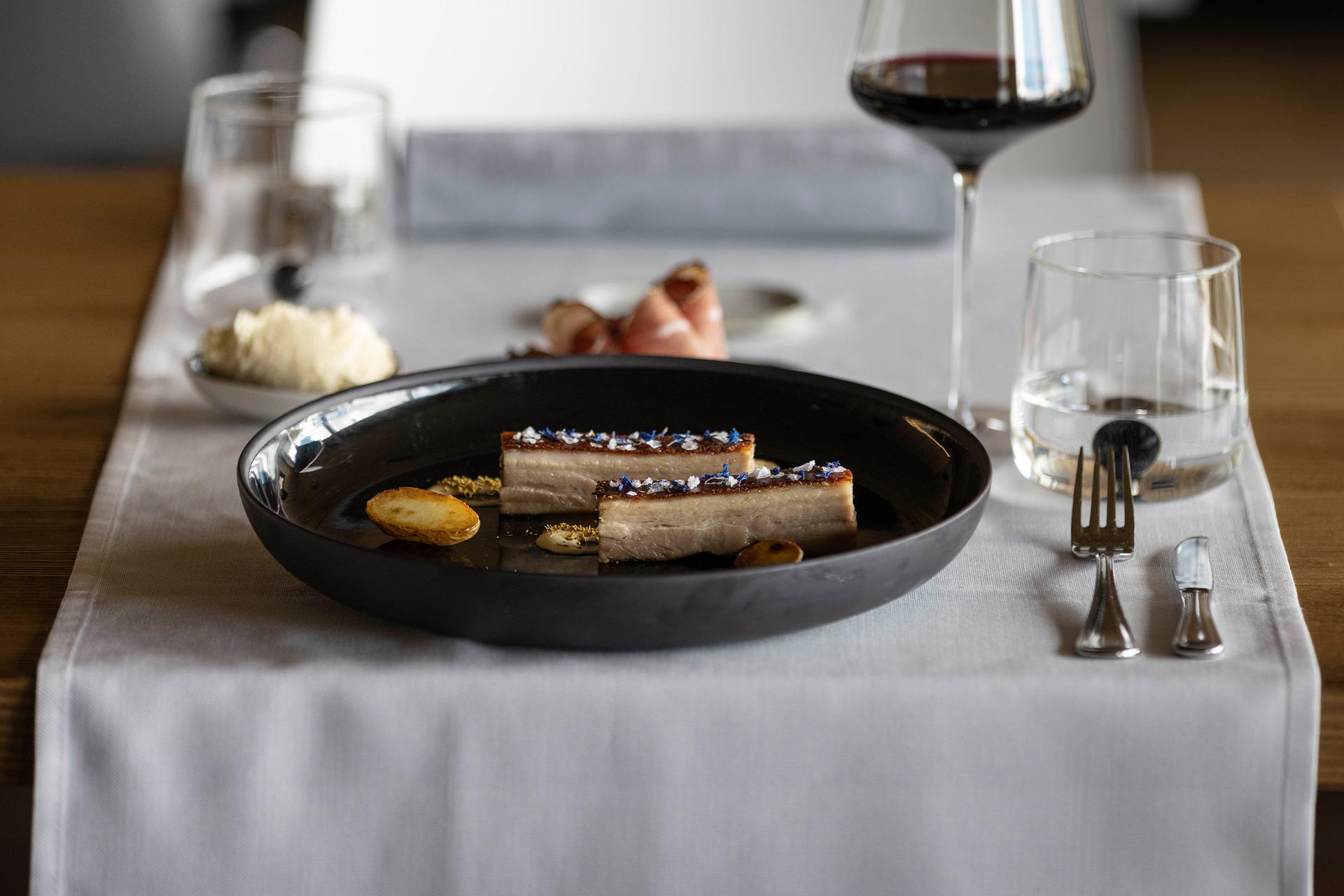 Gefüllte Tortelli garniert mit Parmesanflocken, begleitet von einem raffinierten Weißwein Hotel Ciasa de Munt in Alta Badia 